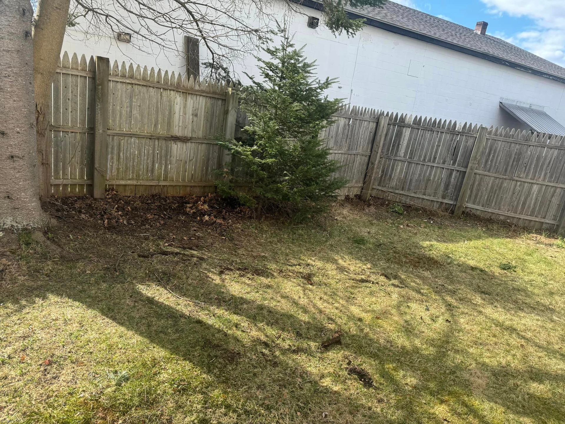 There is a wooden fence in the backyard of a house.