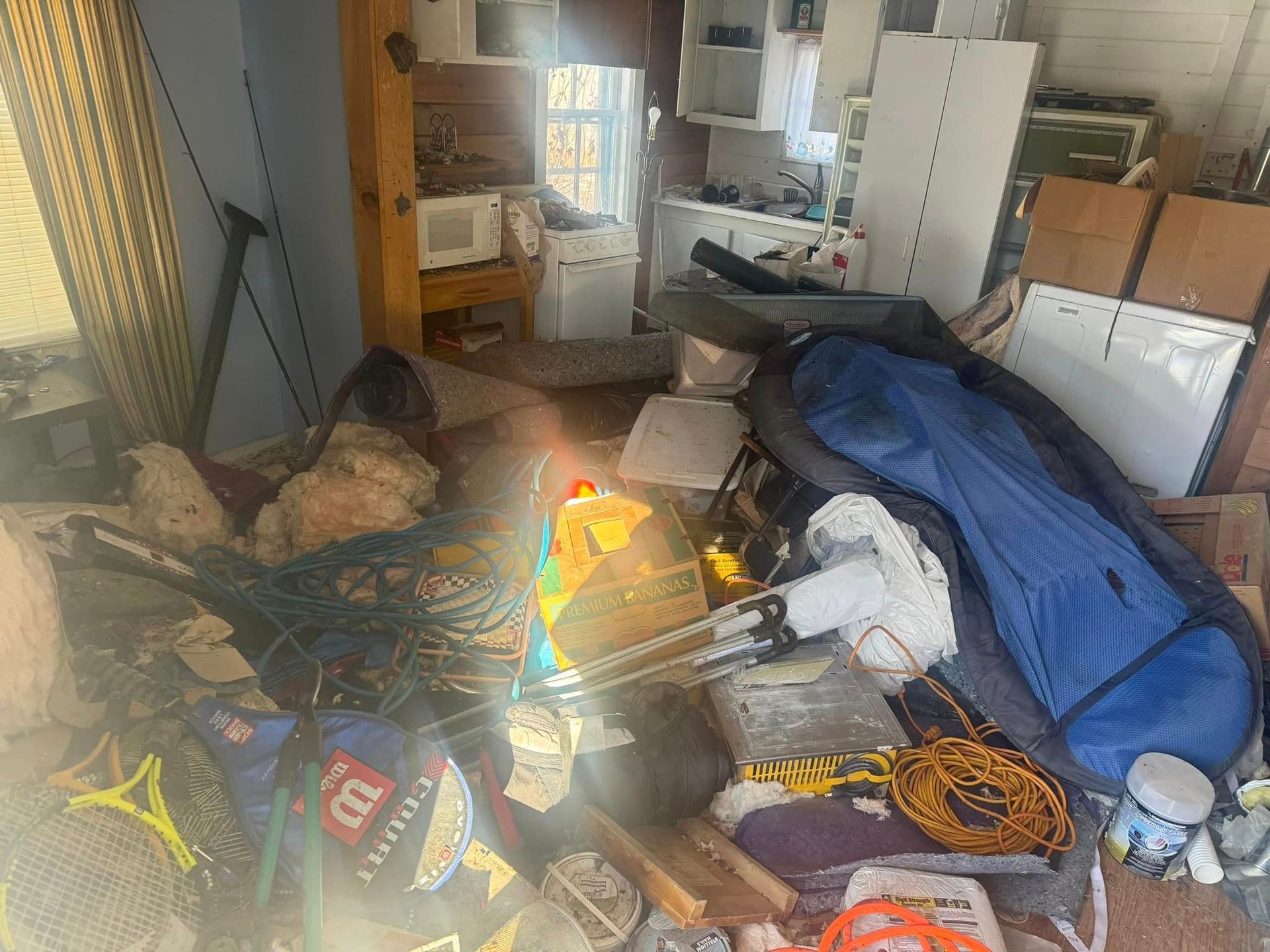 A room filled with lots of junk and a tennis racket.