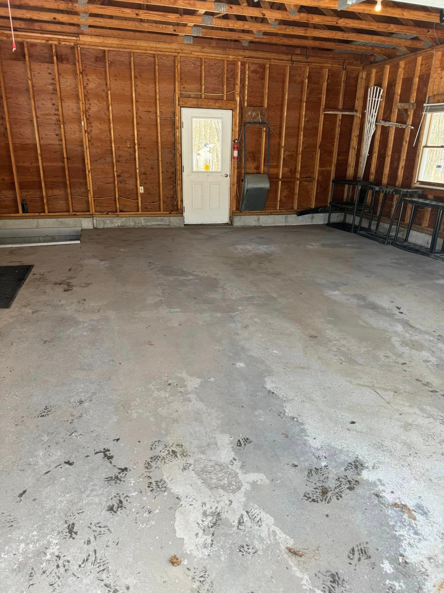 A garage with a concrete floor and wooden walls.