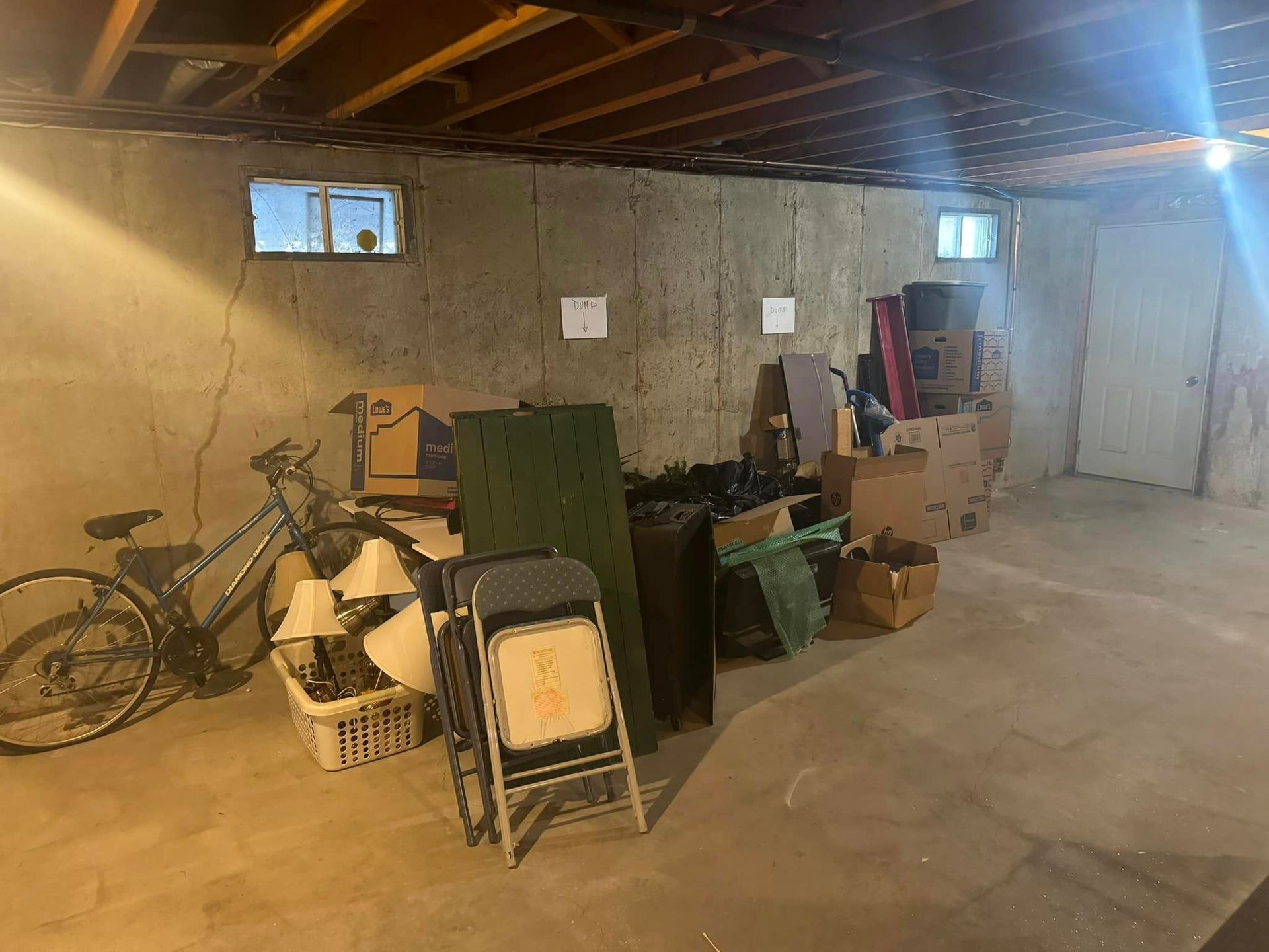 A basement filled with lots of boxes and a bicycle.