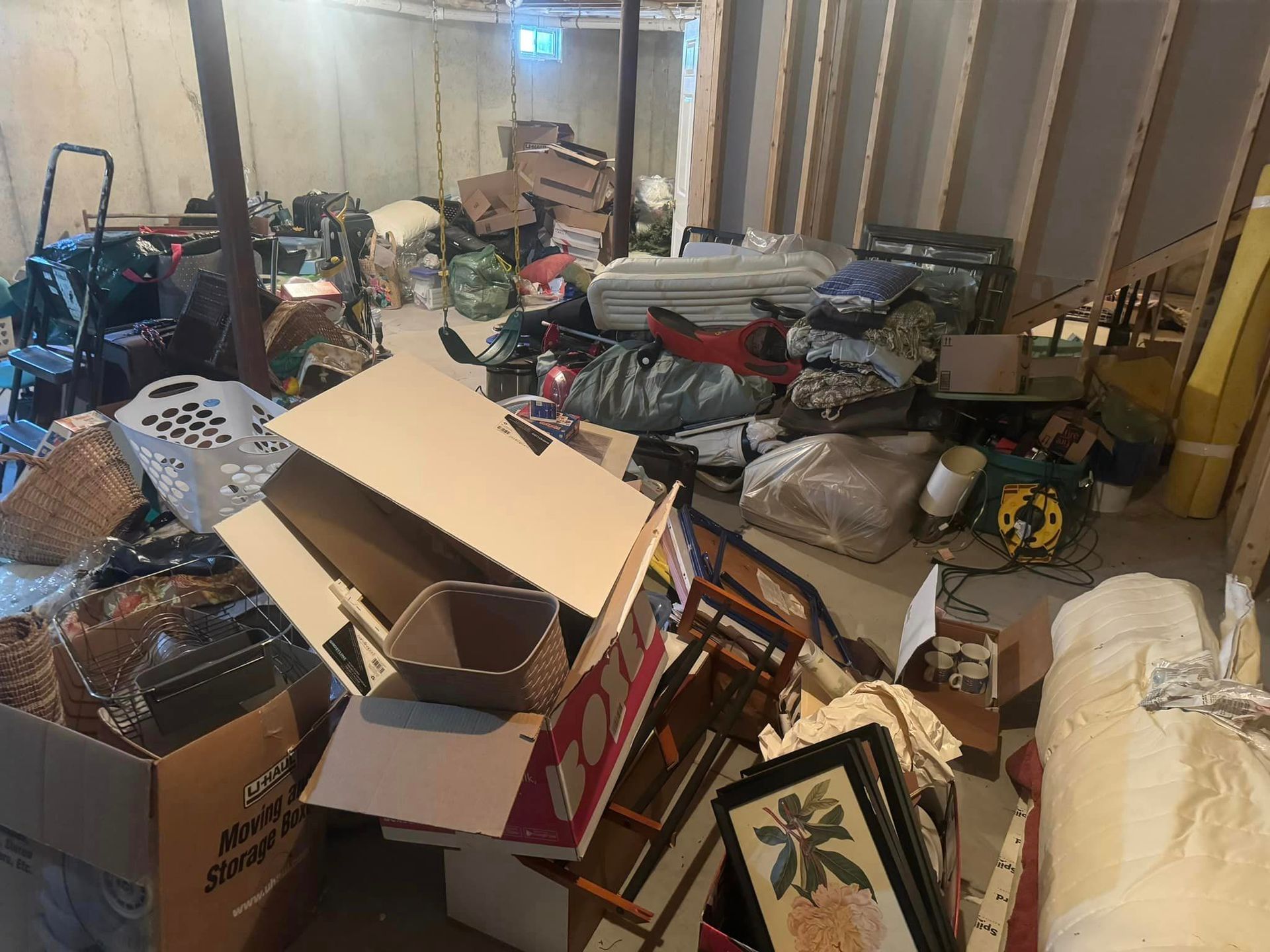 A basement filled with lots of boxes , pictures , and other items.