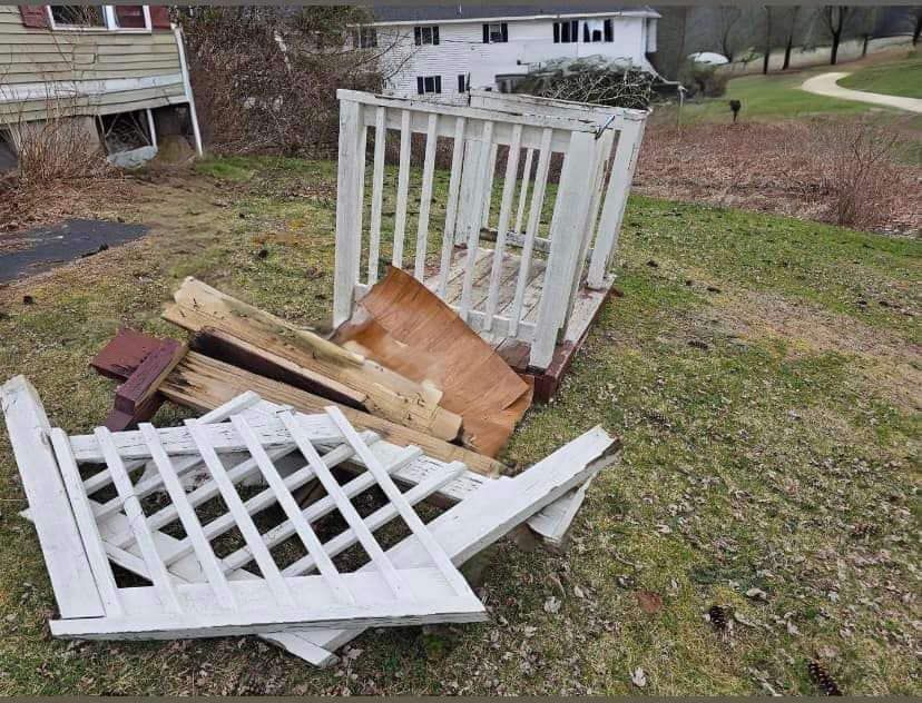A white lattice fence is sitting on top of a pile of wood.