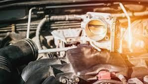 Throttle body assembly in a car engine compartment.