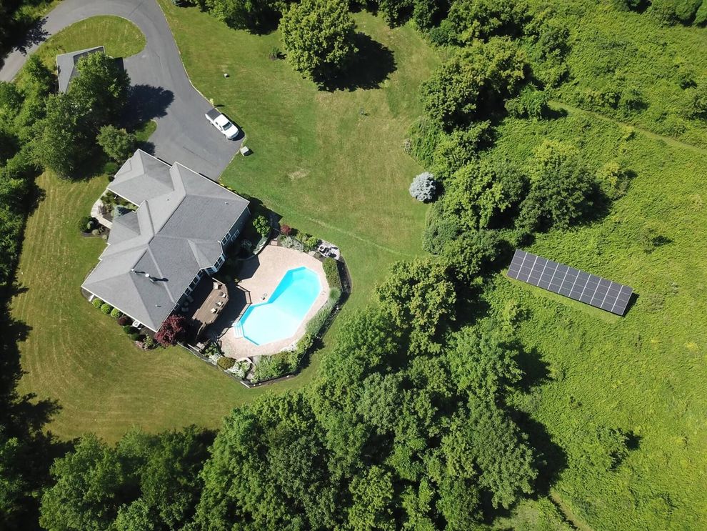 an aerial view of a house with a pool and solar panels