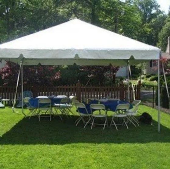 A white tent with tables and chairs underneath it
