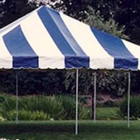 A blue and white striped tent is sitting on top of a lush green field.