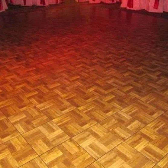 A wooden dance floor with red lights behind it