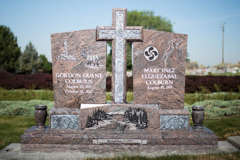Custom granite headstone for Colburn and Mark with cross centerpiece and individual photo medallions