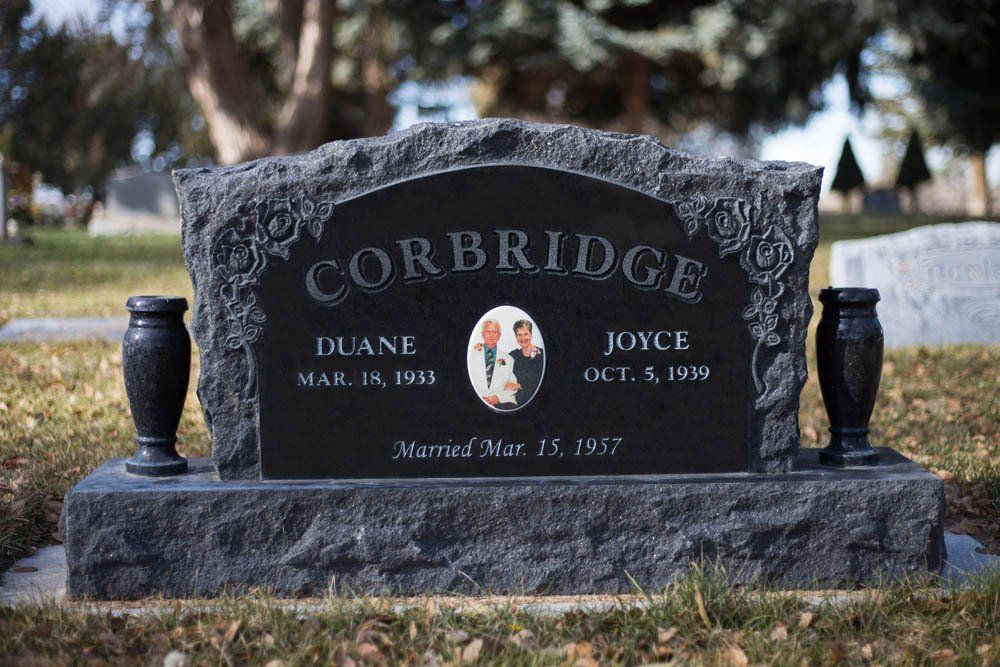 Black granite headstone for Diane and Joyce Corbridge with floral design and polished finish