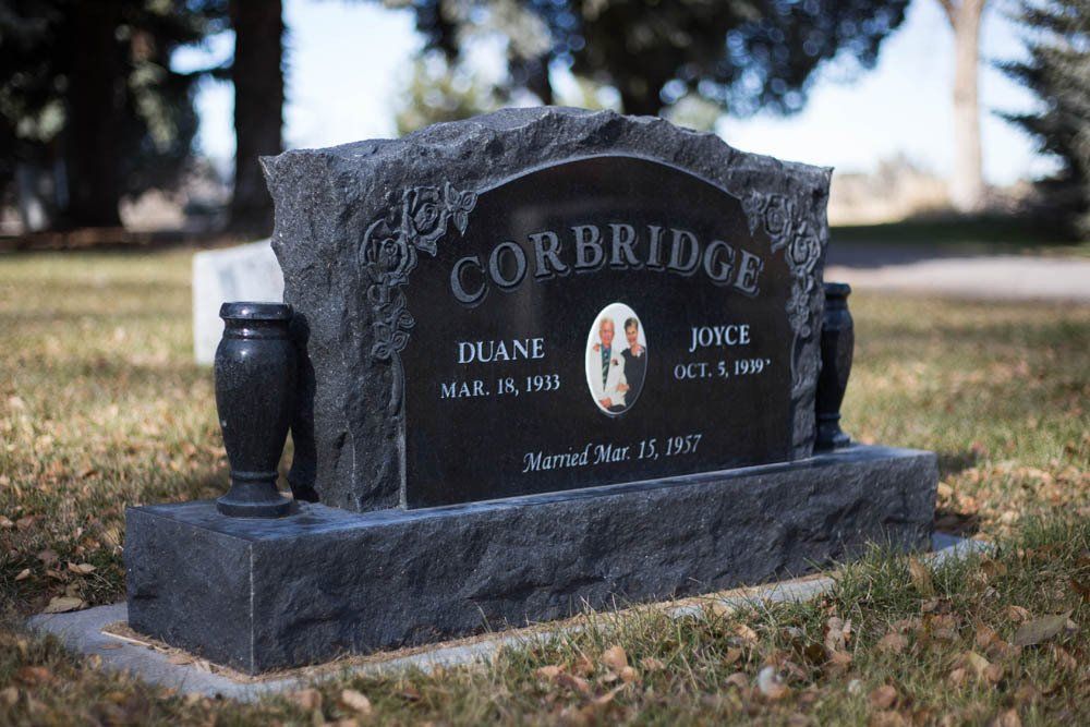 Angled view of Corbridge headstone with floral engravings and centered family name