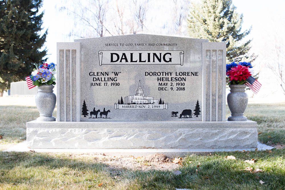 Front view of Dalling family granite monument with horse-drawn carriage scene and vase arrangements
