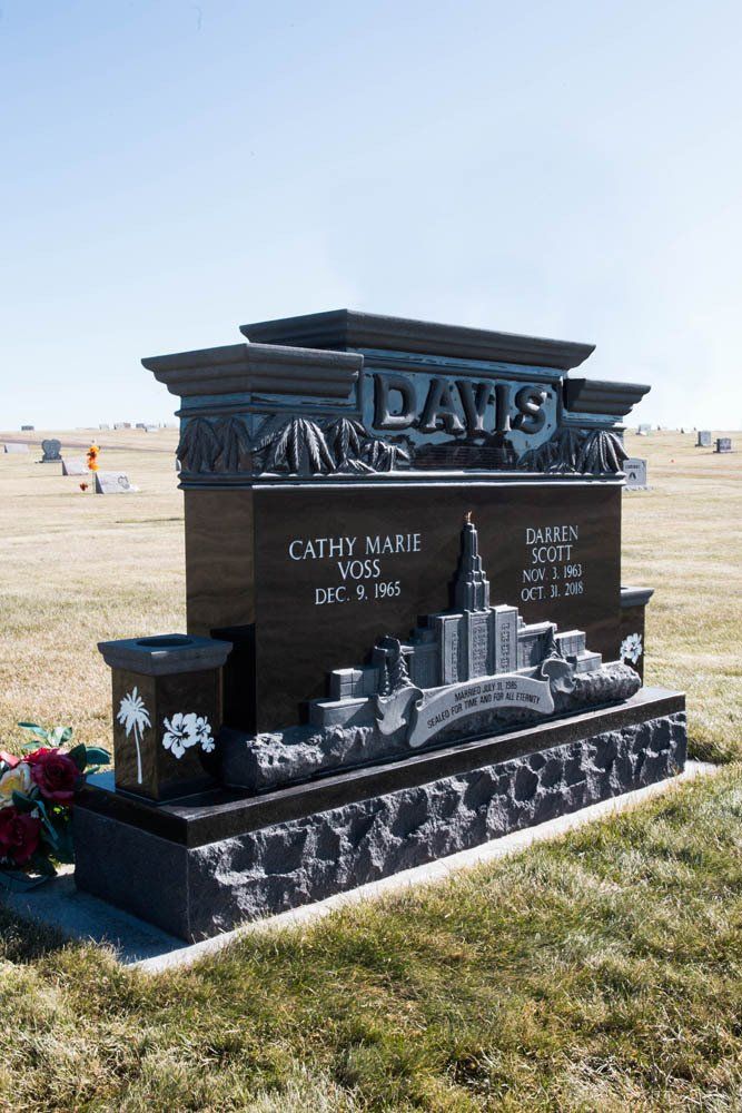 Side view of Davis family monument with etched temple, name panels, and flower vases