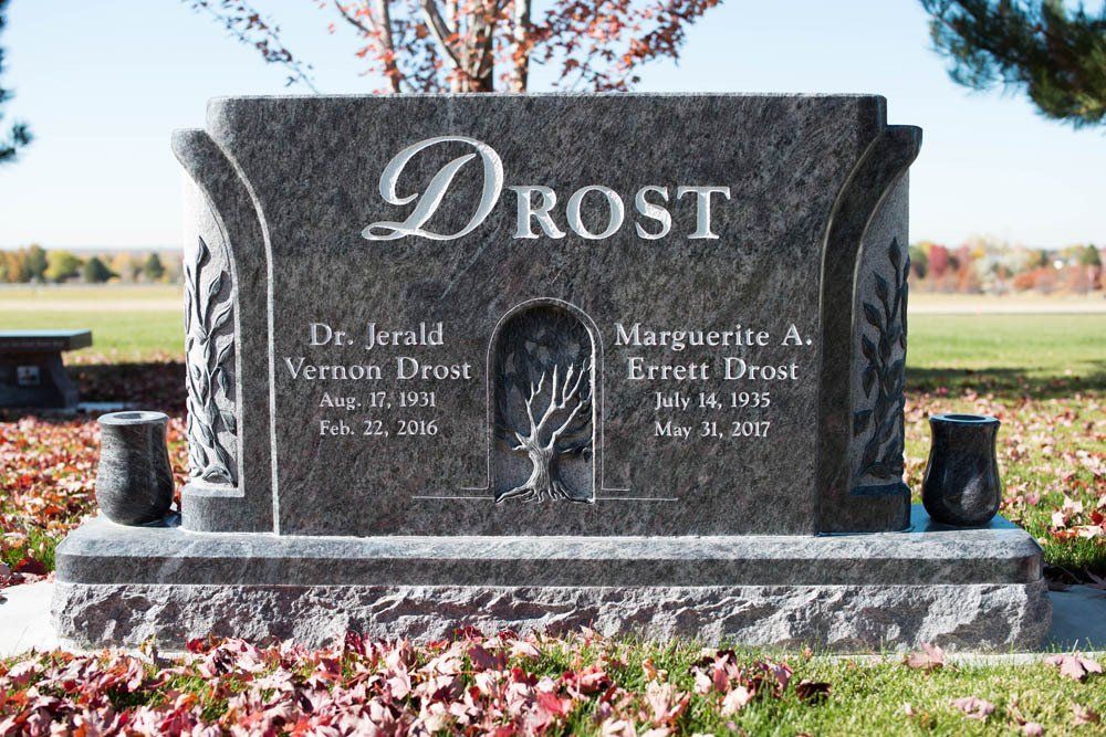 Full frontal granite memorial for Jerald and Margerita Drost with floral detail and dual vases