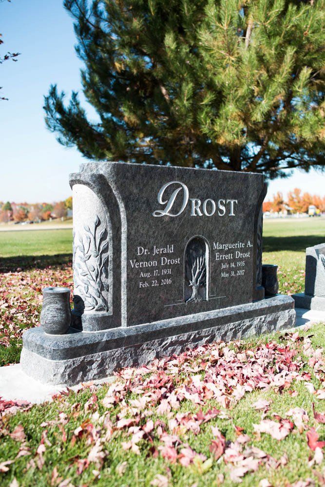 Decorative curved granite memorial for Dr. Jerald Drost with rose carvings and personalized inscription