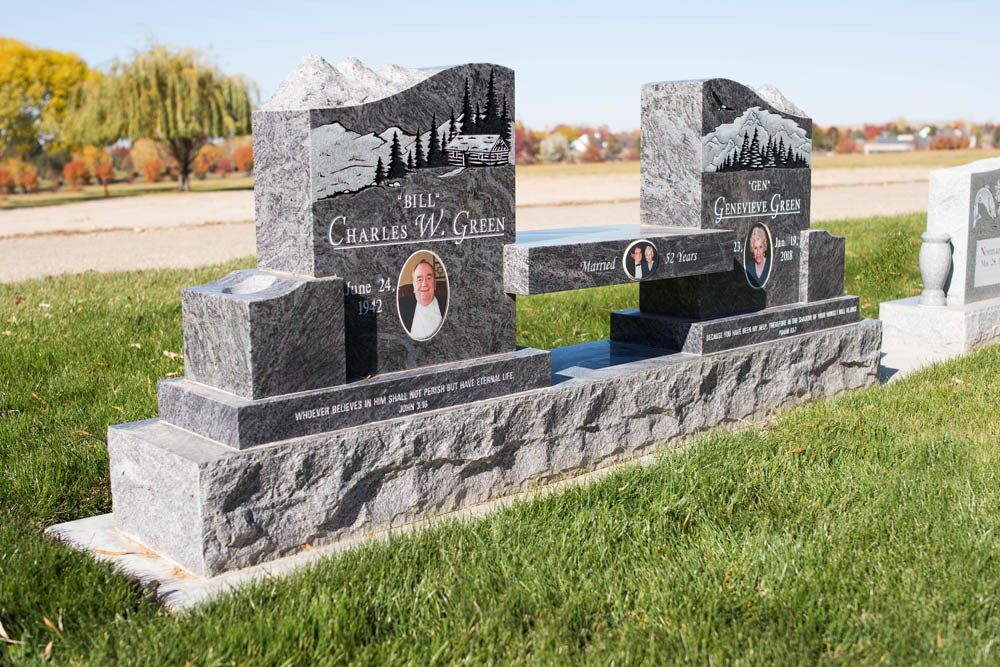 Side view of Green family monument with carved trees, mountains, and individual portrait panels