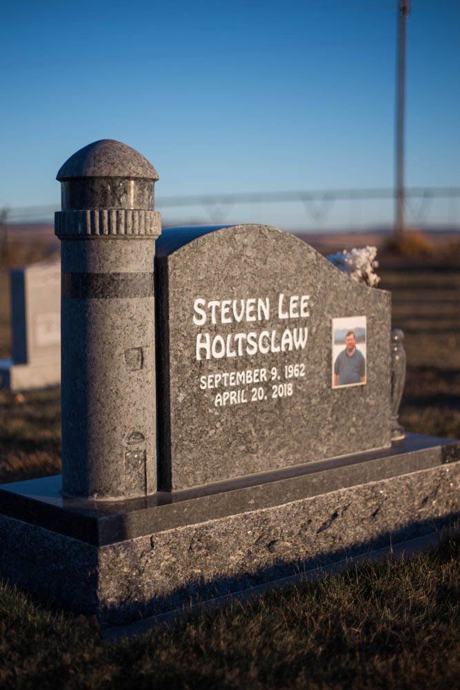 Close-up side view of Steven Lee Holtsclaw memorial featuring rounded top and inlaid portrait