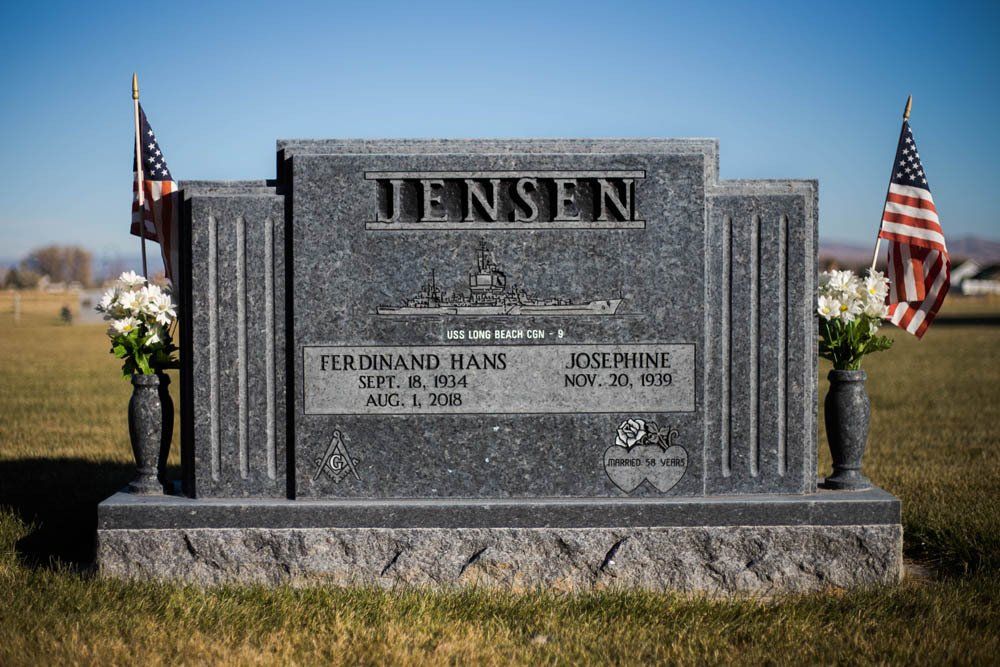 Frontal view of Jensen family headstone with engraved names and symmetrical floral urns