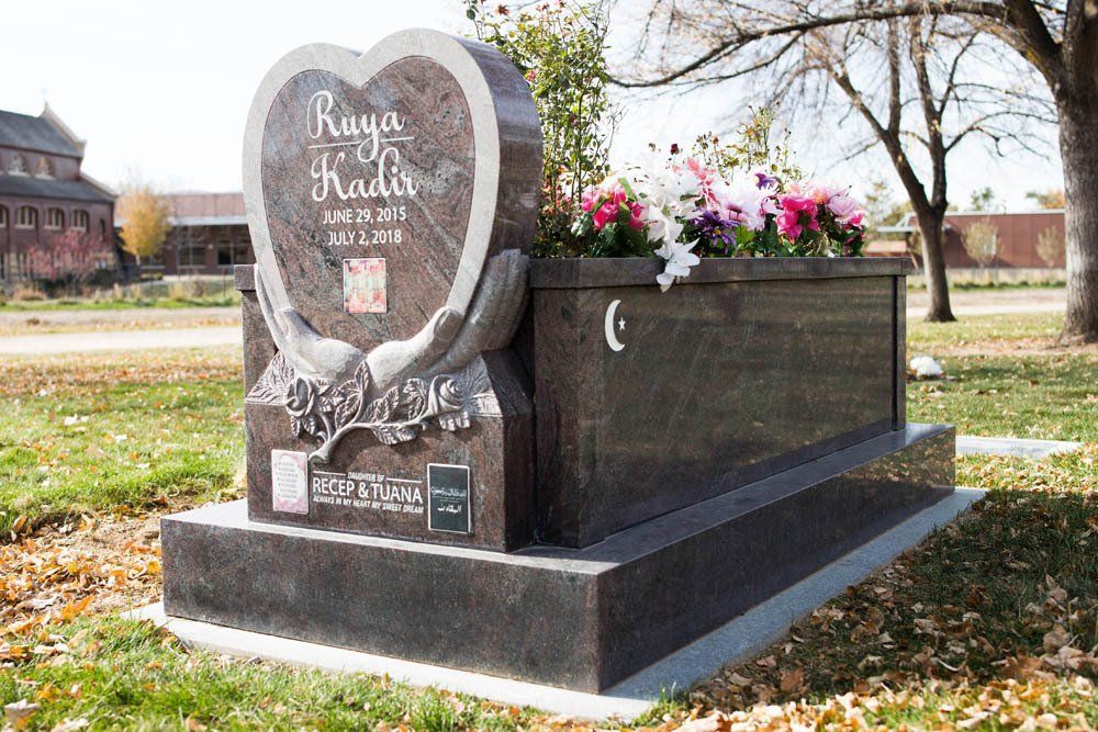 Heart-shaped child memorial for Ruya Kadir with engraved hands, flowers, and loving tribute inscription