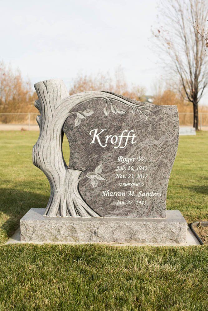 Full front view of Krofft memorial with leaf carvings and natural trunk-style border
