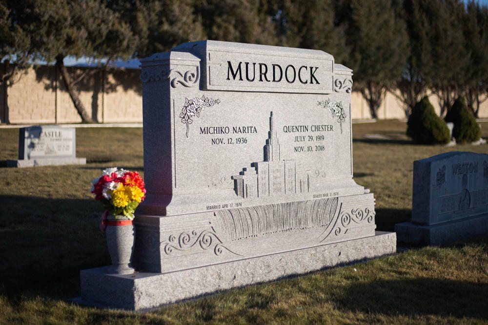 Side view of Murdock family headstone featuring temple etching and decorative corner engravings