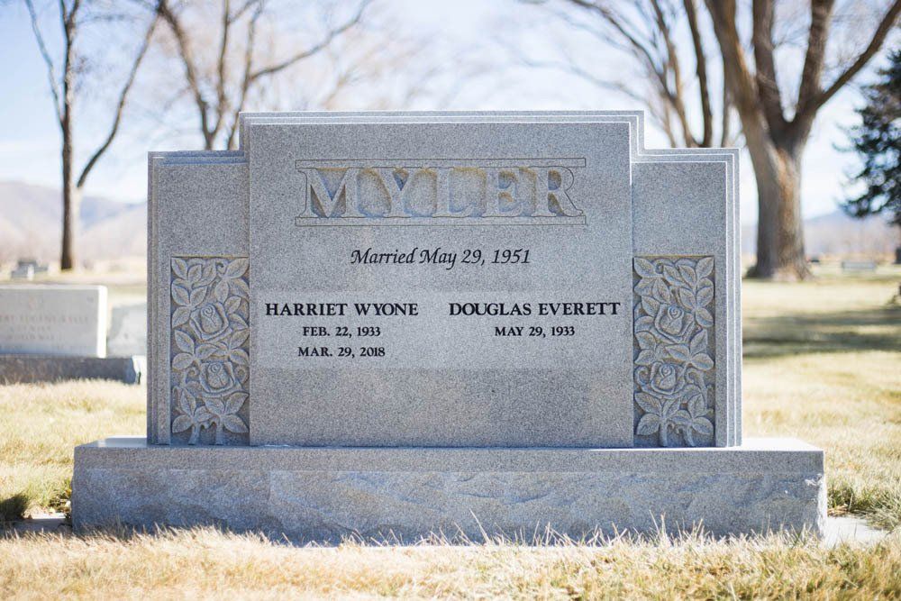 Granite headstone for Harriet and Douglas Myler with floral side carvings and classic serif font