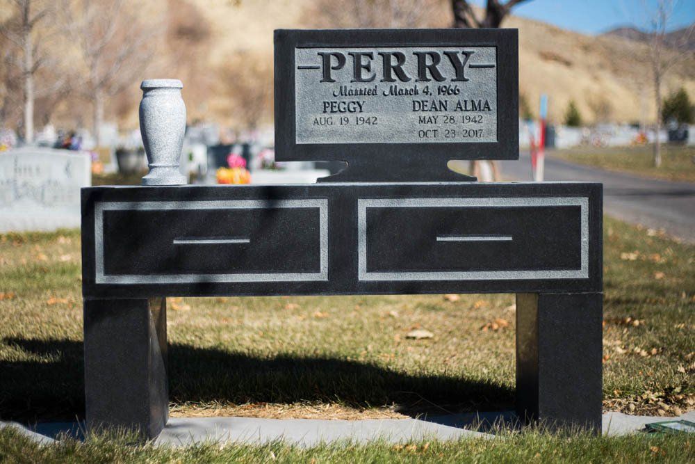 Front view of Perry family headstone designed as a black granite desk with engraved names and keyboard detail