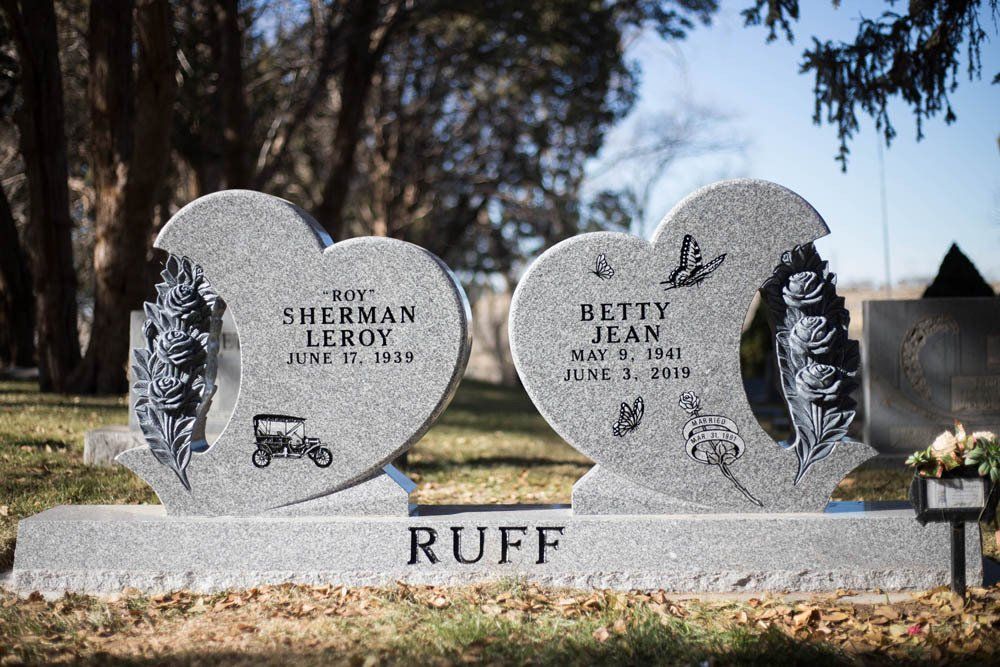 Front view of Ruff family monument with double hearts, vintage car, butterflies, and rose engravings