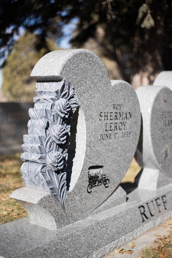 Side view of heart-shaped headstone with sculpted roses and engraved name Roy Sherman Leroy
