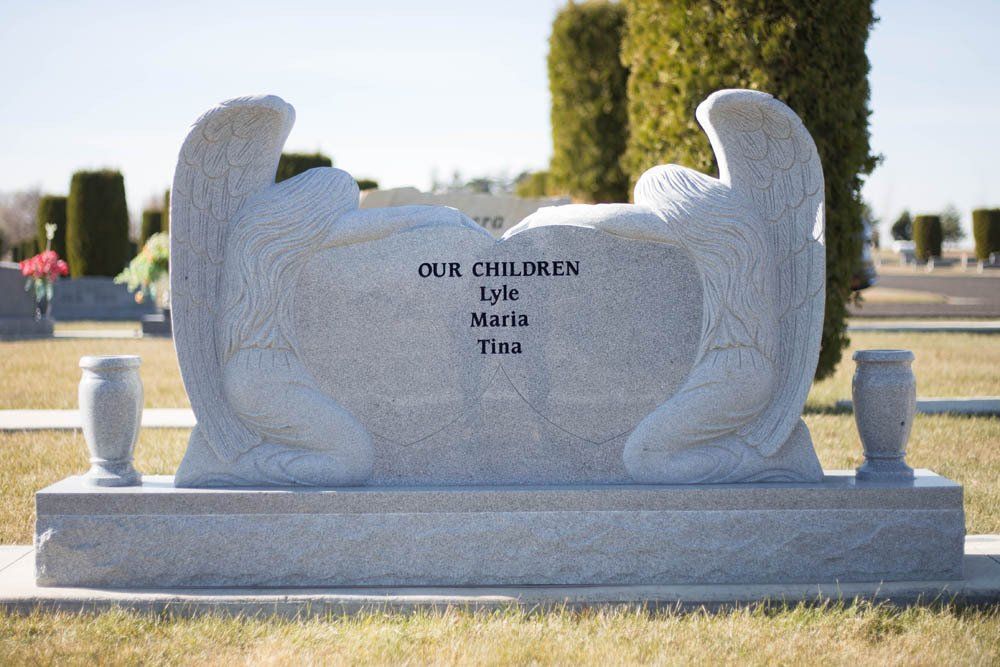 Unique double angel monument with the inscription “Our Children: Lyle, Maria, Tina”
