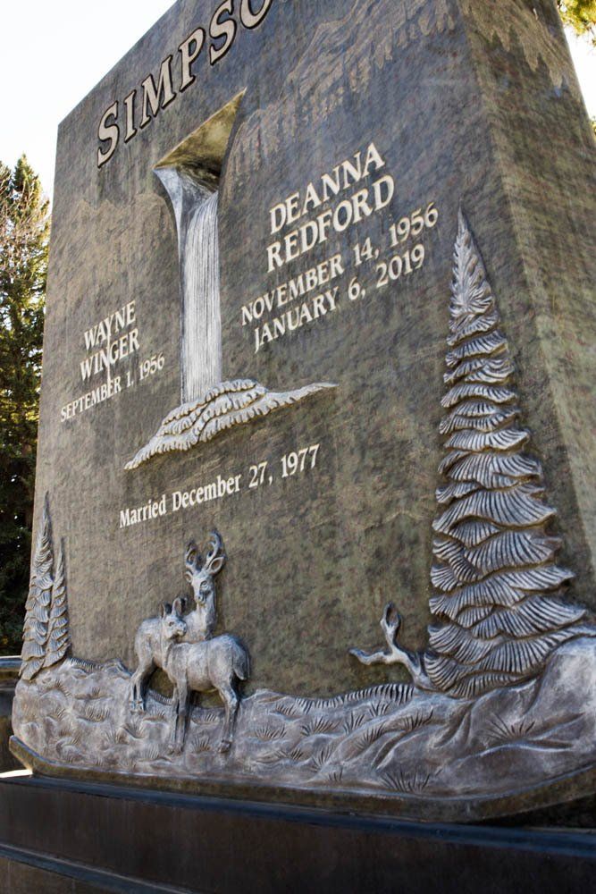 Close-up of waterfall and pine tree carvings on Simpson family headstone