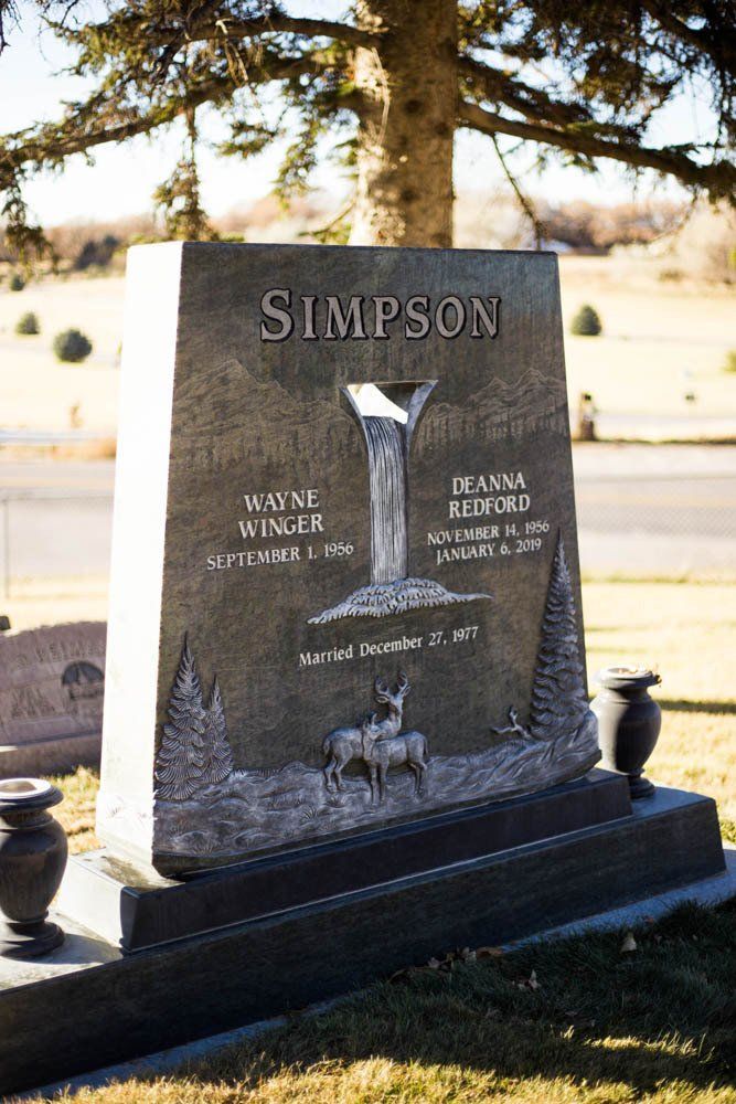 Nature-themed Simpson family headstone with carved waterfall, deer, and mountain landscape