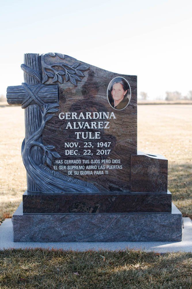 Close-up of engraved granite headstone for Gerardina Alvarez Tule with sculpted cross design