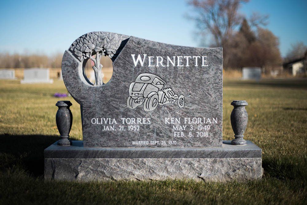Custom headstone with carved truck and tree imagery for Olivia Torres and Ken Florian Wernette