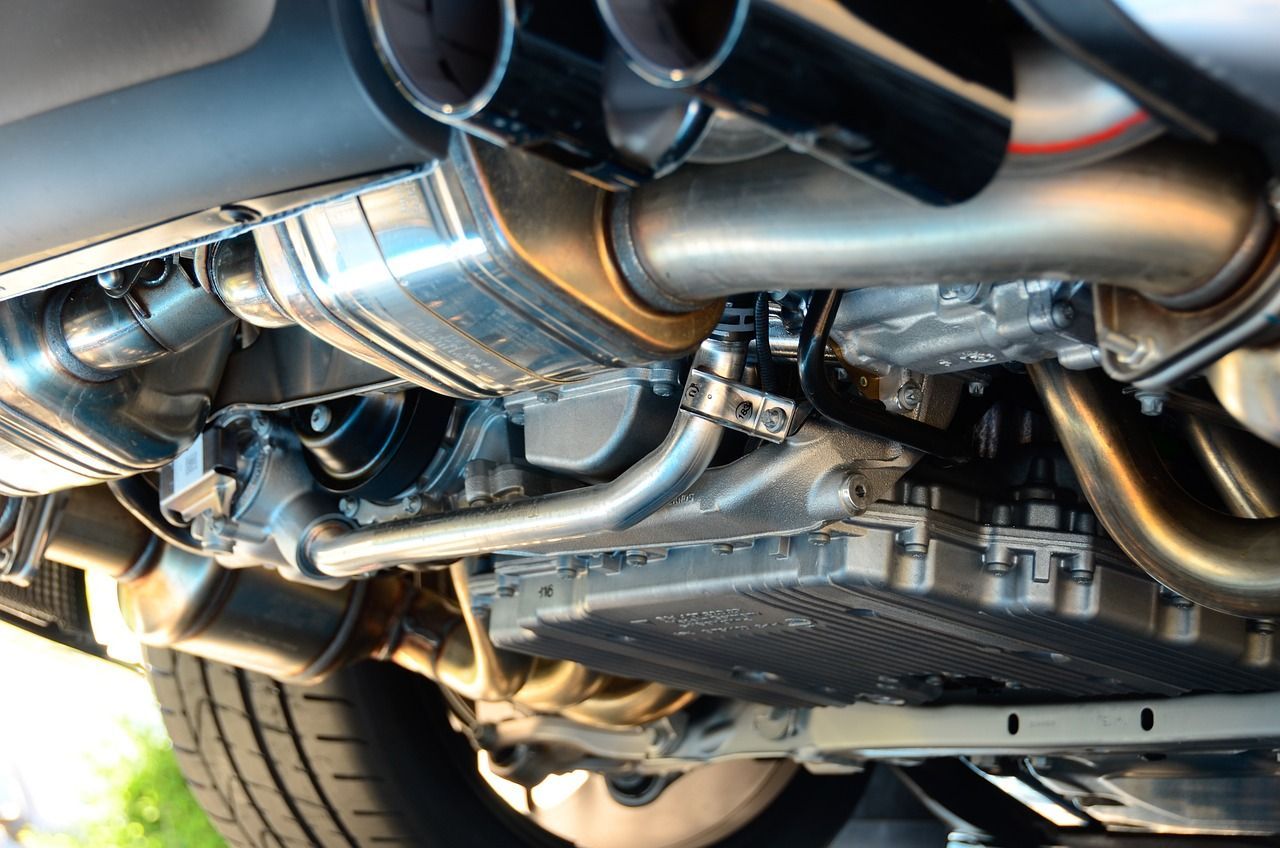 Undercarriage view of a car’s shiny exhaust and suspension components