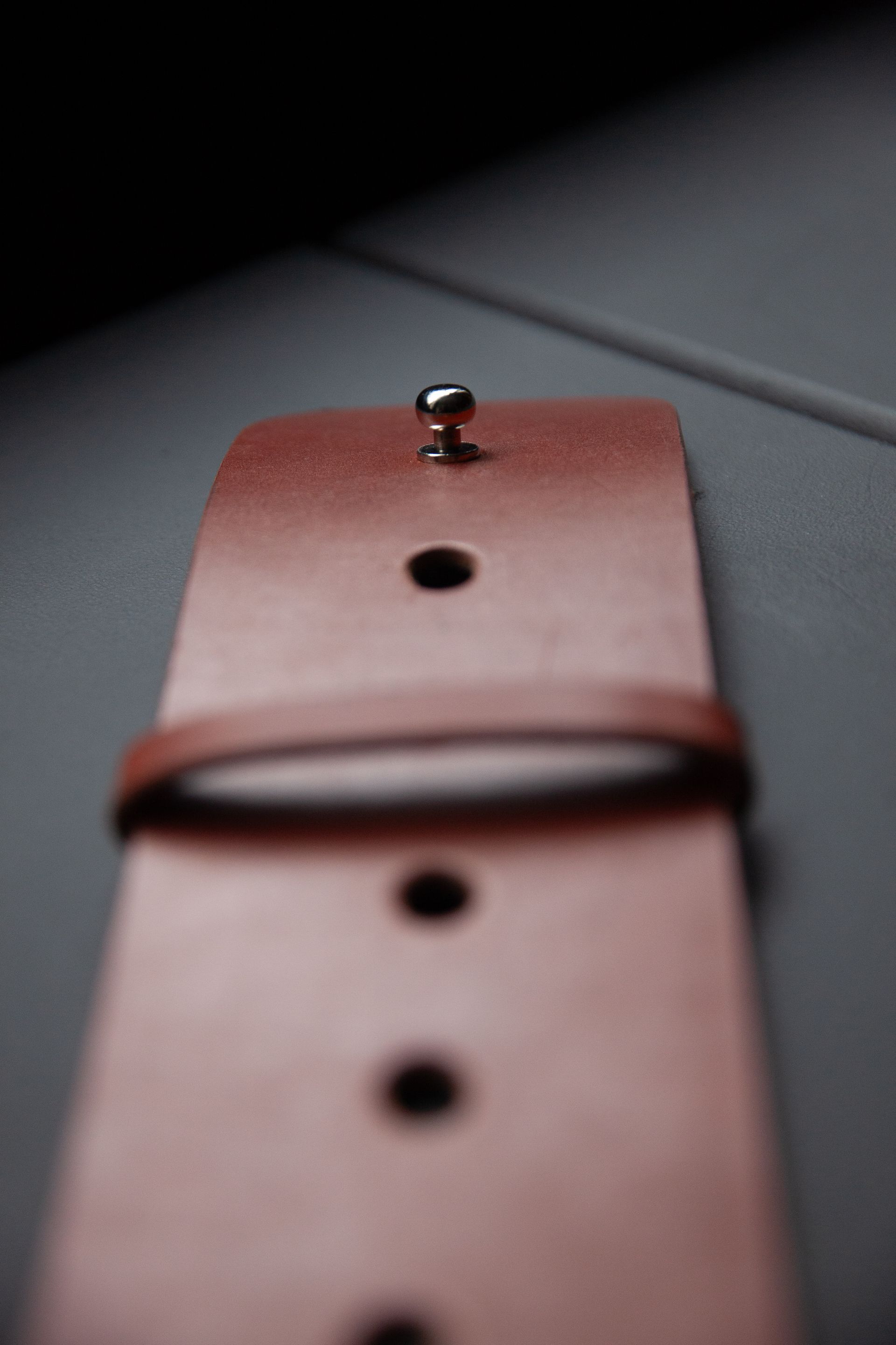 A close up of a brown leather watch band on a table.