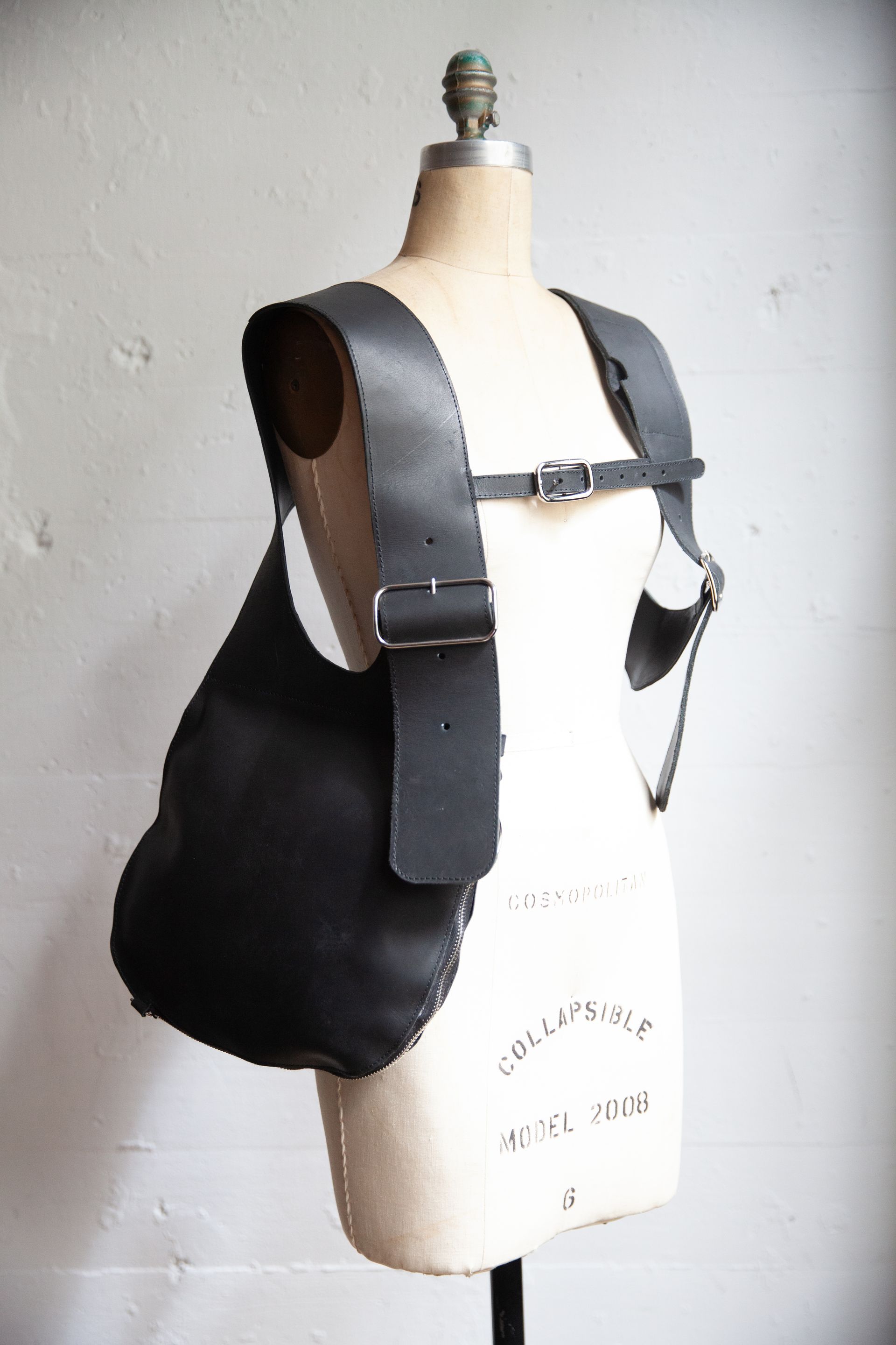 A mannequin is wearing a black leather vest