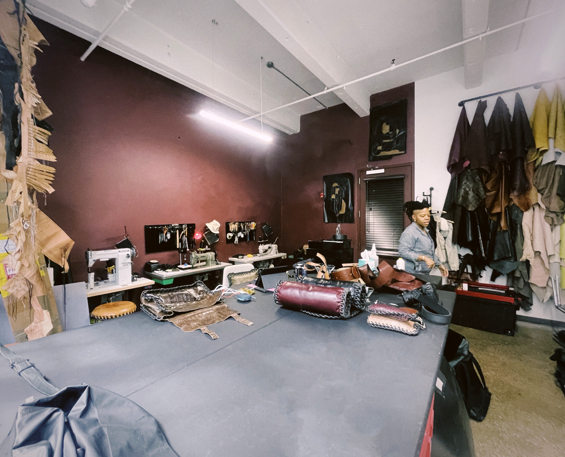 A woman working on a piece of leather in a workshop
