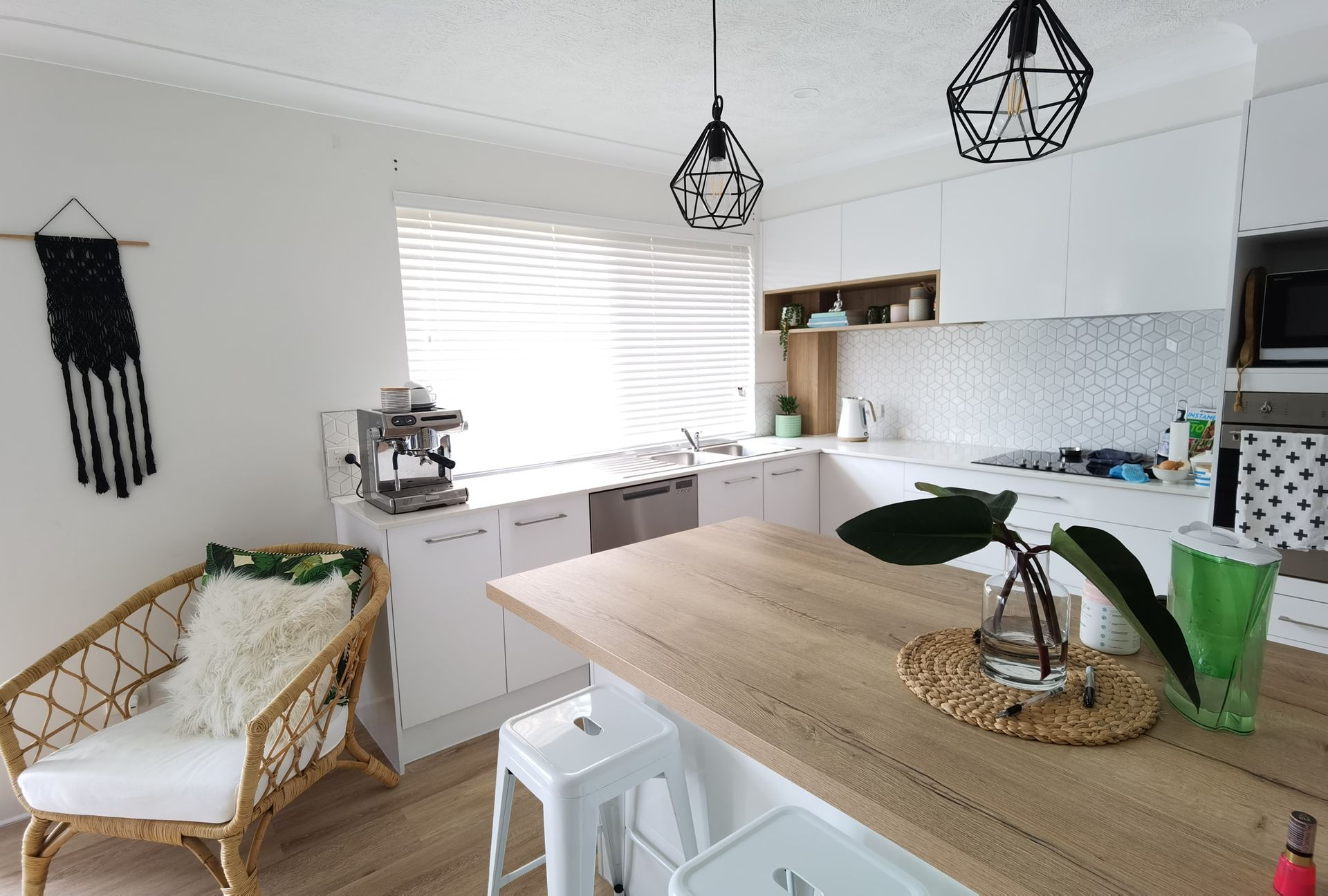 A kitchen with white cabinets and a wooden counter top