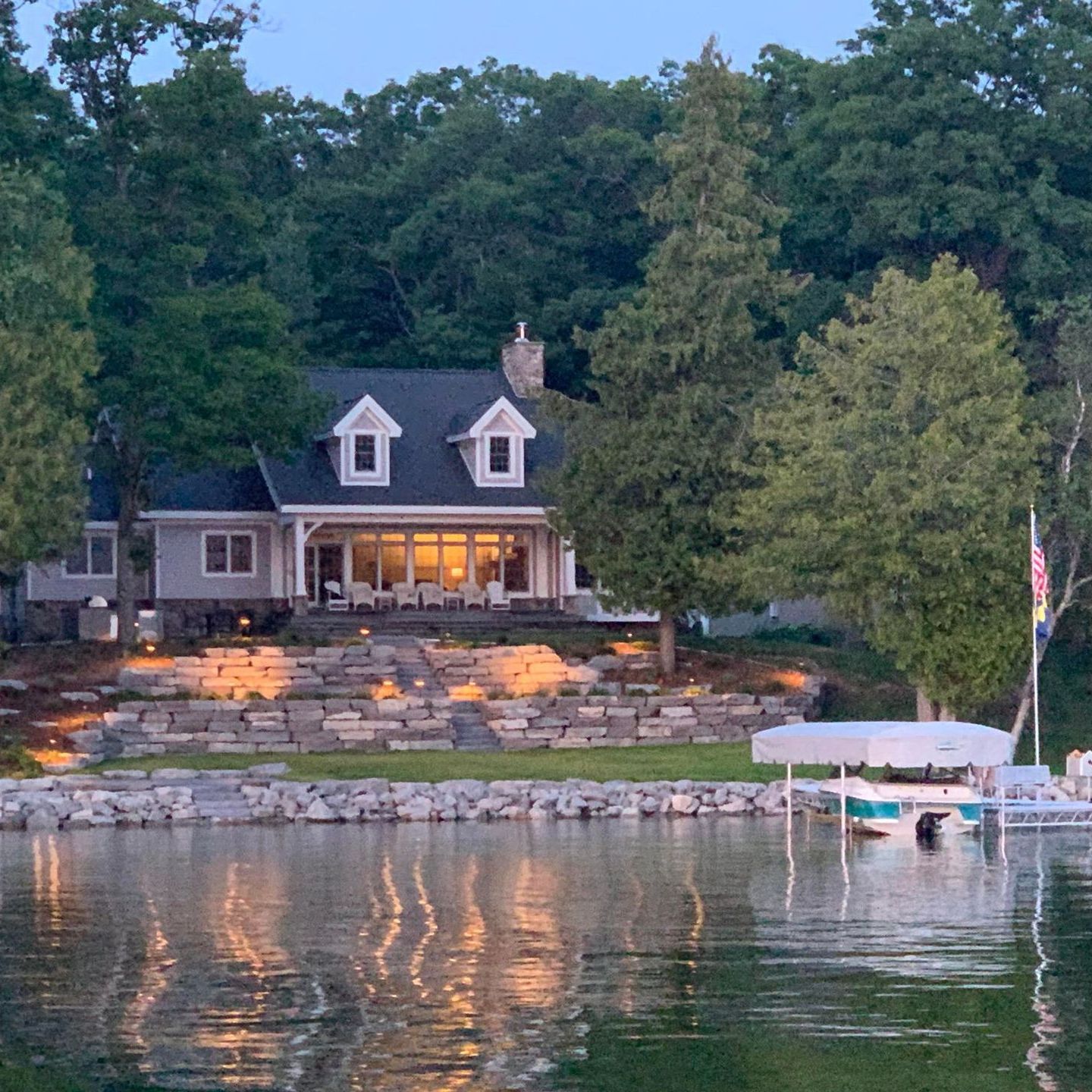 A luxury house sits on the shore of a lake