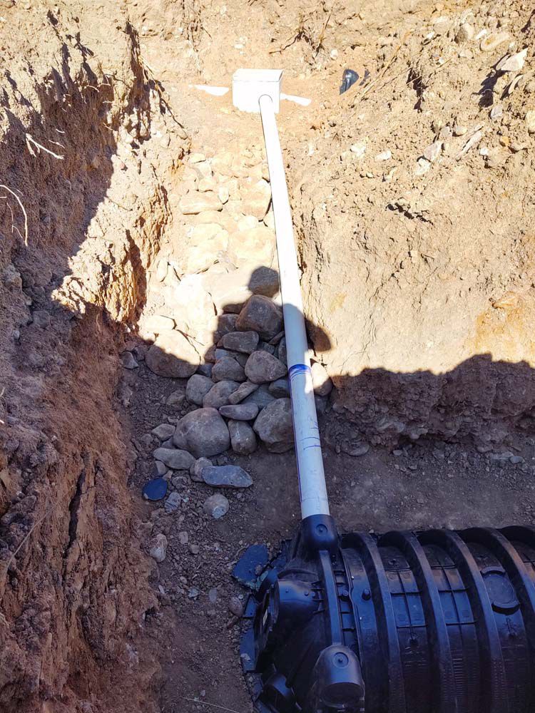 A pipe is being installed in a hole in the ground