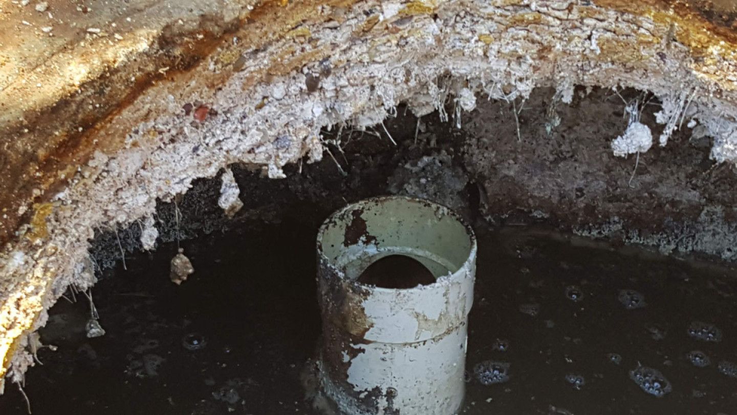 A white pipe is sitting in the middle of a hole in the ground