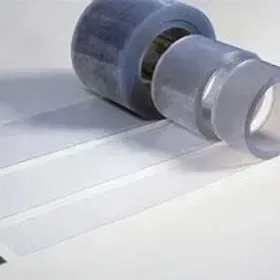 Rotolo di nastro adesivo trasparente con strisce srotolate su una superficie bianca.