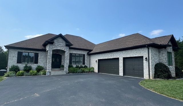 A large white house with two garages and a driveway