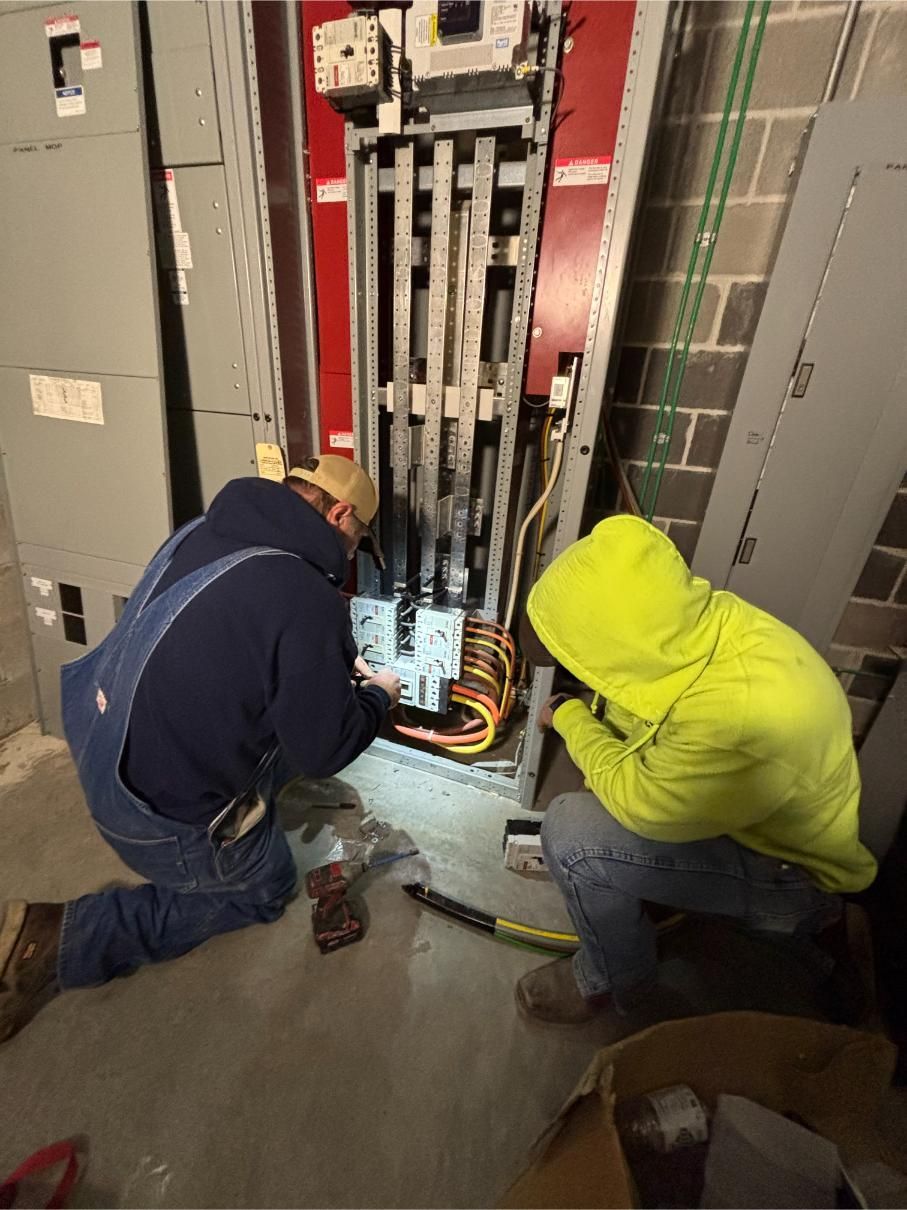Steel frame of a building under construction against a bright blue sky with wispy clouds.