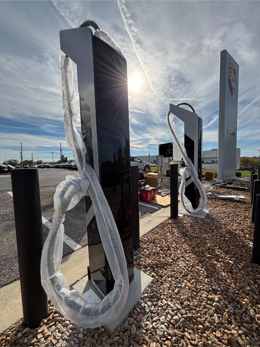 Construction workers reviewing blueprints at a building site, one points up.