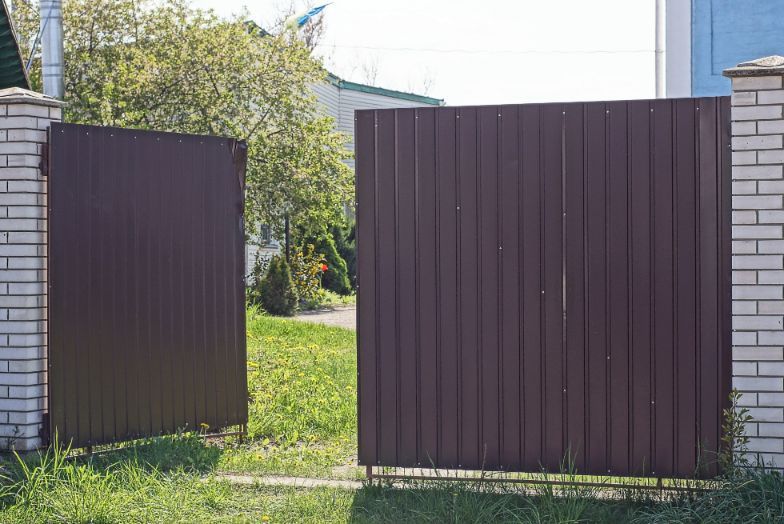 Red brown Colorbond gate installed in a residential garden in Wollongong NSW.