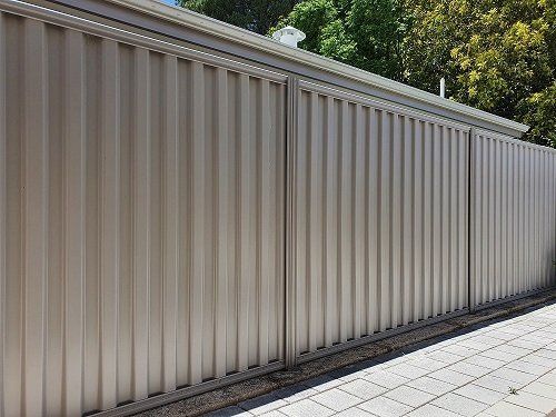 Newly installed cream Colorbond fencing for privacy and aesthetics in a property in Wollongong NSW. 