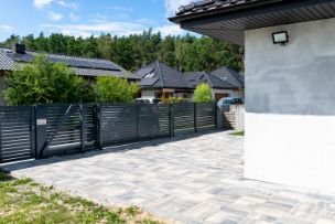 Long modern black painted metal sliding gates in Wollongong NSW residential property.