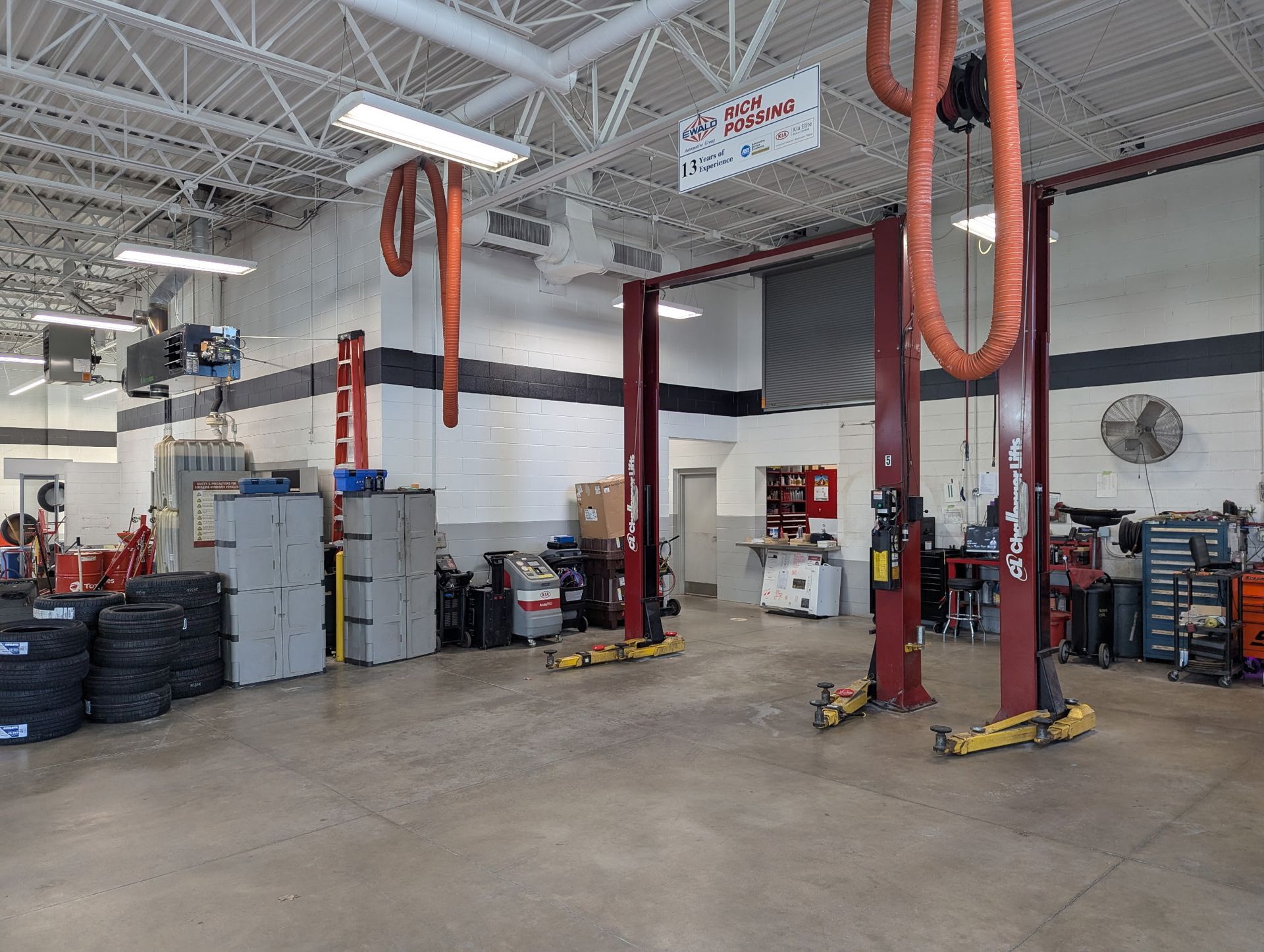 A car repair shop interior with vehicle lifts, tools, and equipment.