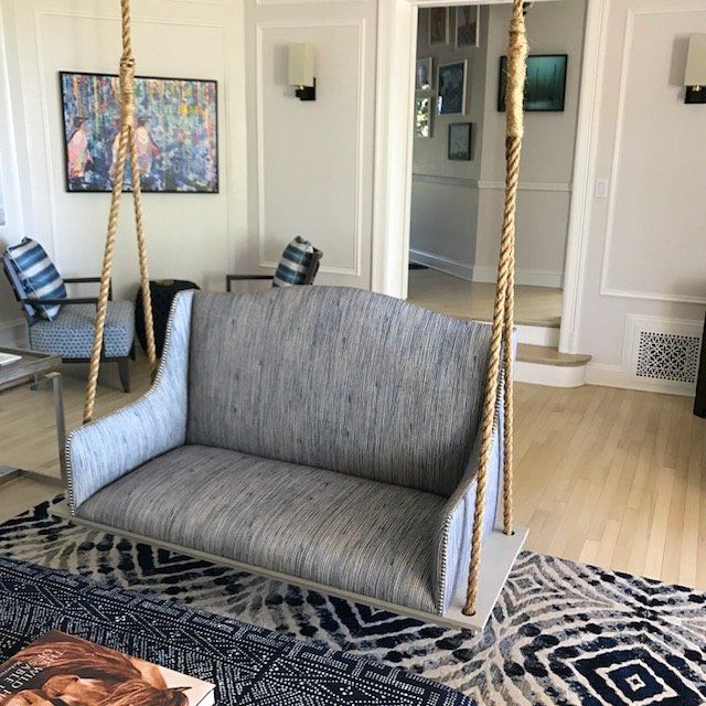 Living room with blue upholstered swing and patterned rug.